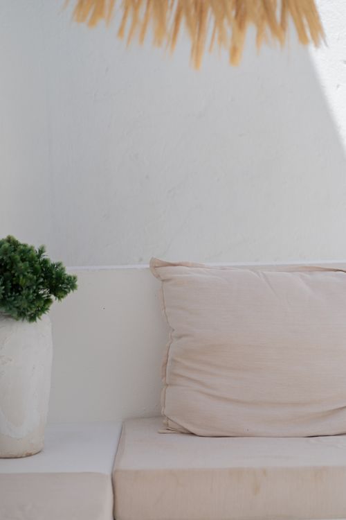 Free Elegant minimalist outdoor sofa with neutral cushion and green plant enhancing a serene atmosphere. Stock Photo