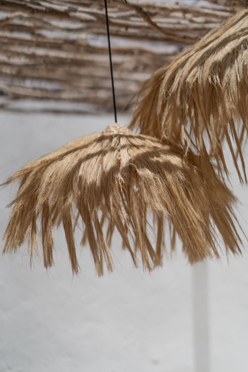 Free Artistic boho style natural reed lampshades hanging outdoors in soft ambient light. Stock Photo