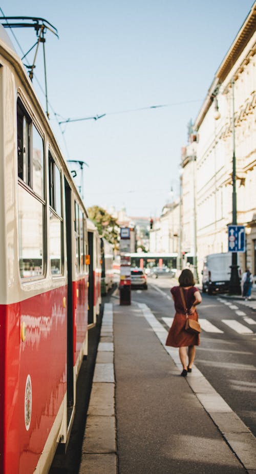 Woman Walking near Tram on Stop