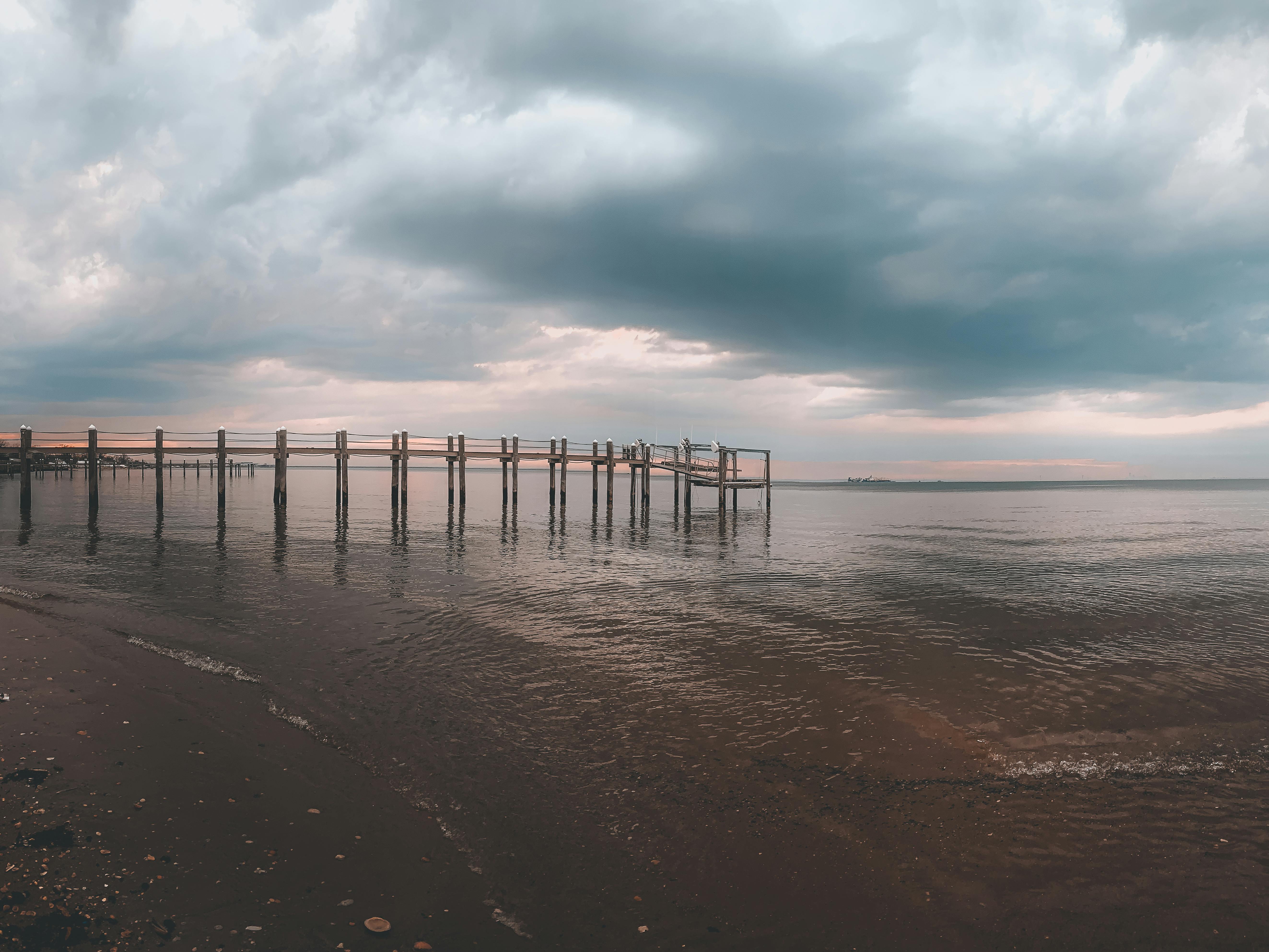 Tranquil coastal scene at Atlantic Highlands with a pier and dramatic sky.