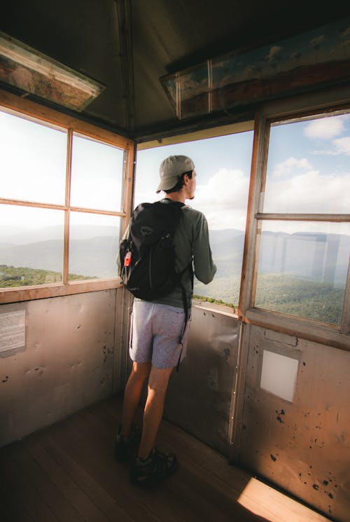 Back View of Man in Backpack and Cap in Tower