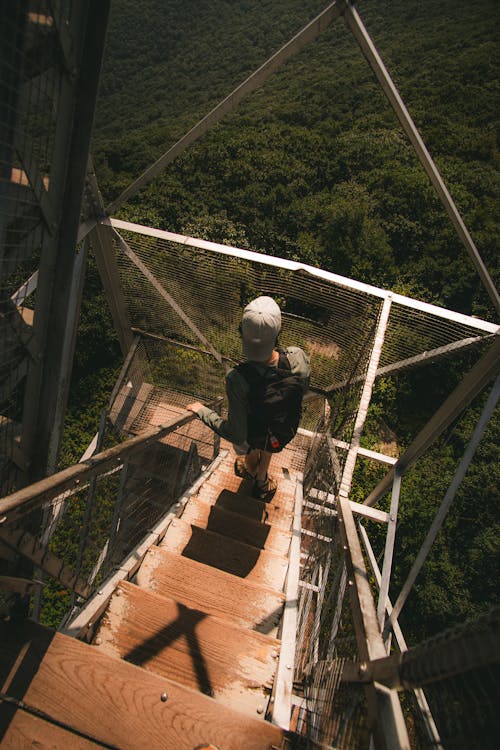 Man Standing on Tower Stairs over Forest