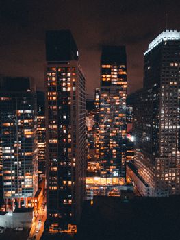Aerial view of a vibrant city skyline illuminated at night, showcasing a bustling urban environment.