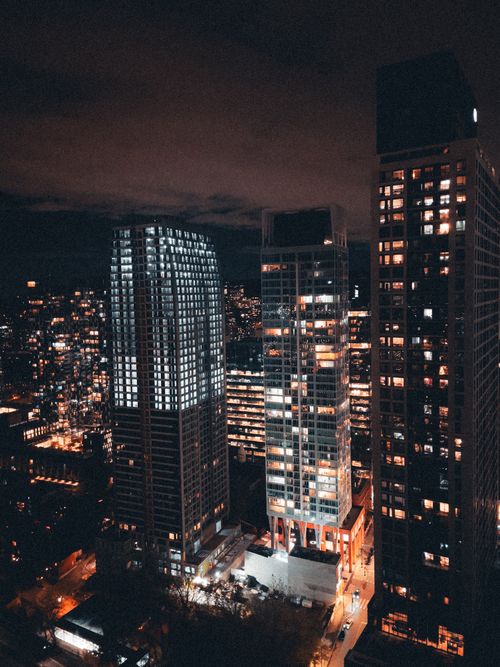 Free Dramatic aerial view of a brightly lit cityscape at night showcasing tall skyscrapers. Stock Photo