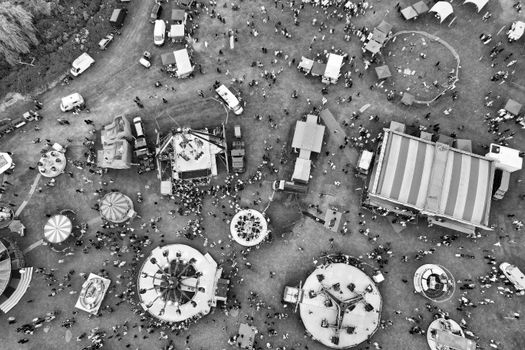 Black and white aerial shot capturing the vibrant scene of an amusement park in Luton, England, filled with people.