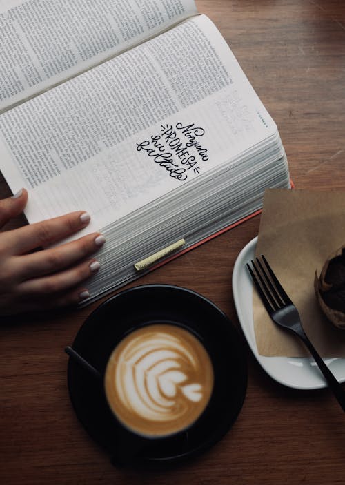 Woman Hand on Book and Coffee