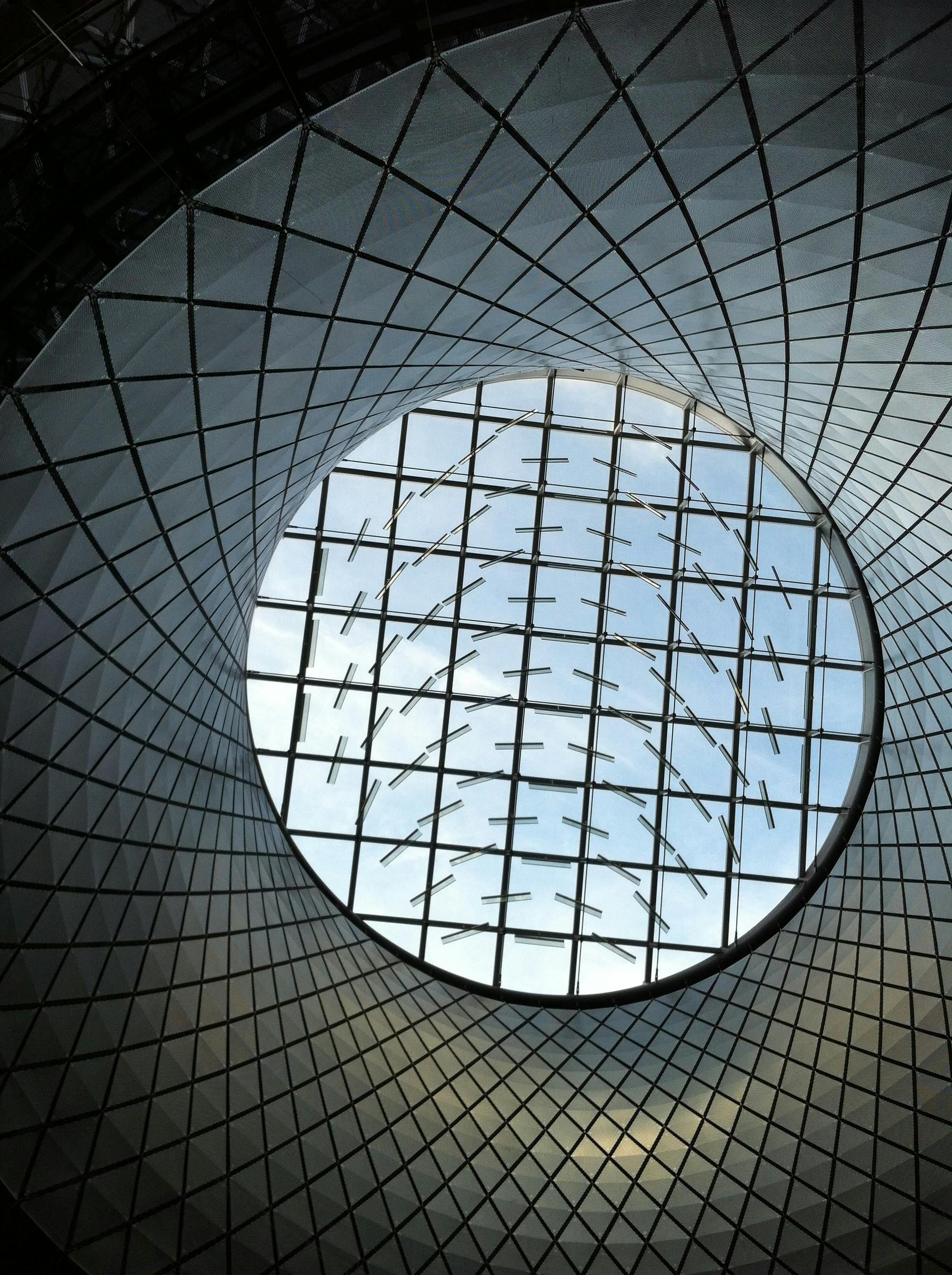 A stunning view of a modern circular glass ceiling at Fulton Center, New York City.