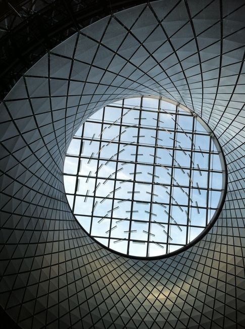 A stunning view of a modern circular glass ceiling at Fulton Center, New York City.