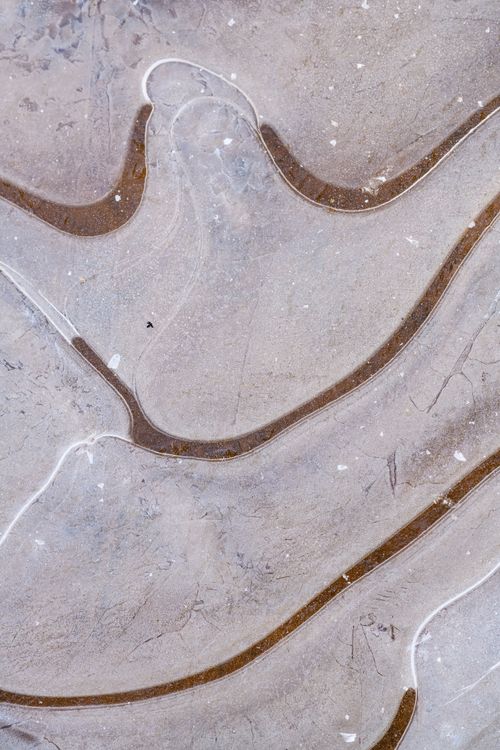 Free Smooth abstract marble stone texture with flowing lines and brown accents. Stock Photo