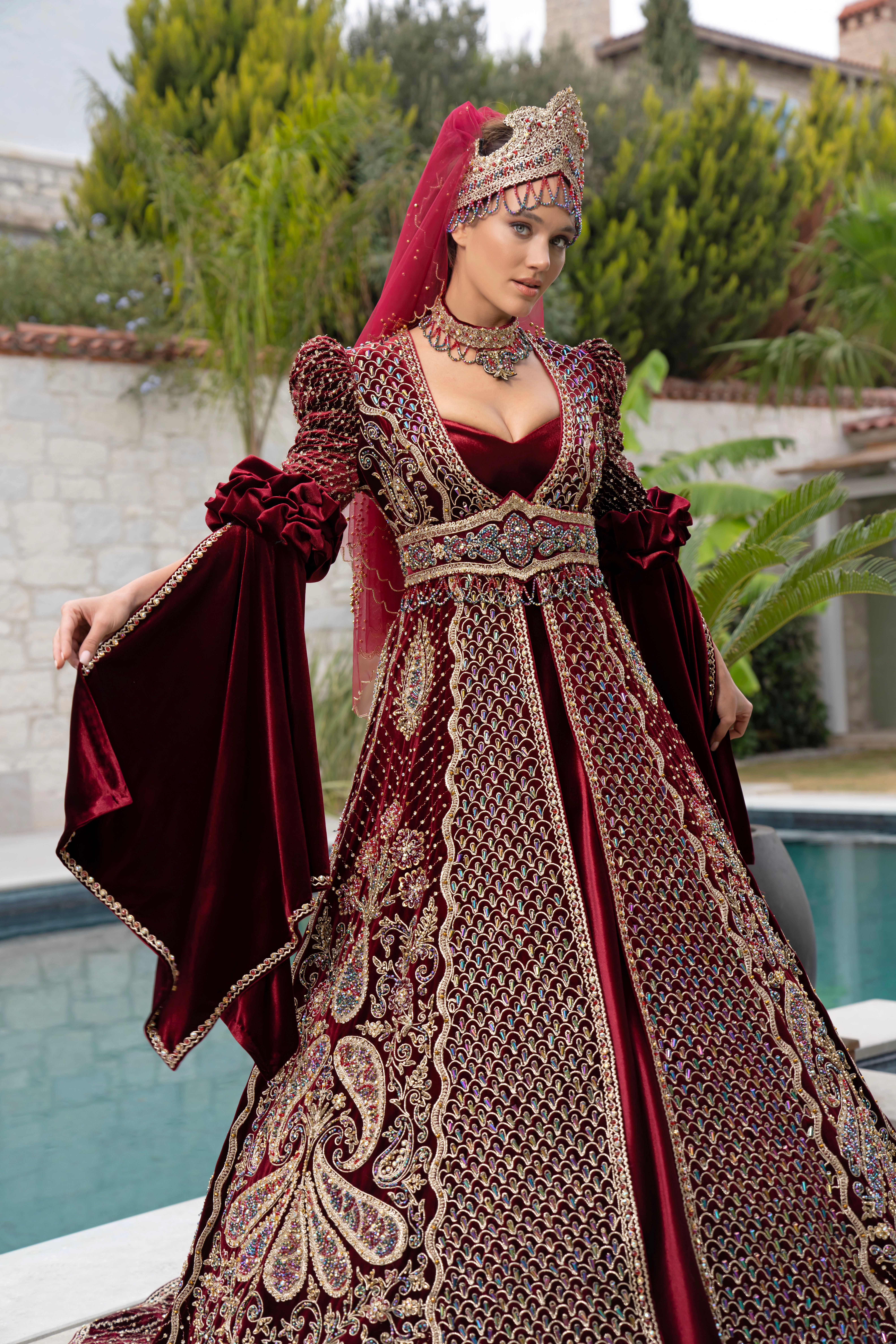 Stunning portrait of a woman in luxurious Turkish bridal dress outdoors.