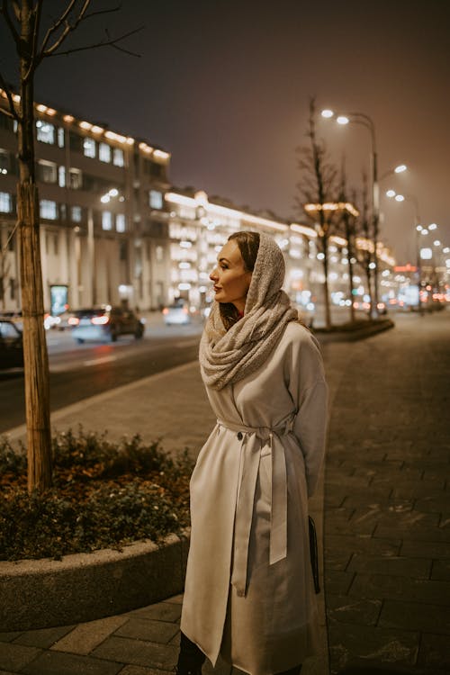 Model in Coat and Headscarf in City at Night
