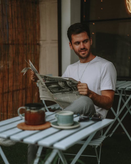 Man Reading Newspaper at Cafe