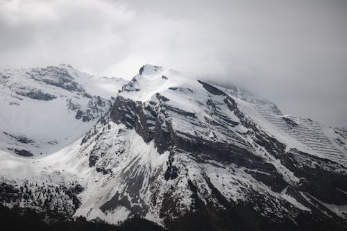 A snow covered mountain with a cloudy sky