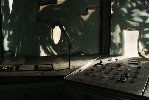 Free Dusty control panel with microphone in an abandoned industrial setting, sunlight filtering through windows. Stock Photo