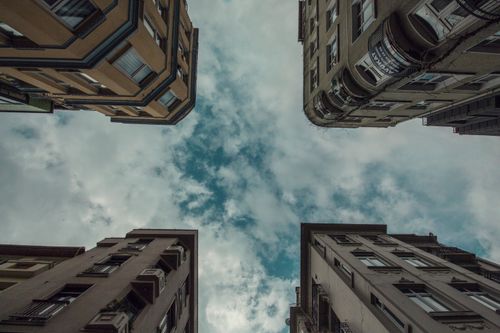 Free Looking up at residential buildings forming a distinct urban skyline against a cloudy sky. Stock Photo