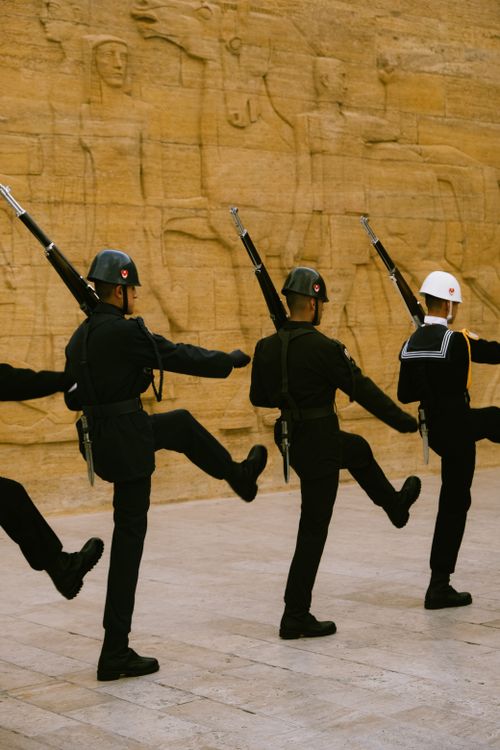 Free Four soldiers march in unison at a historic Turkish mausoleum, showcasing military discipline. Stock Photo