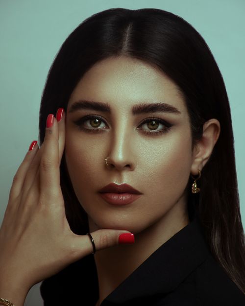 Free Close-up portrait of a woman with bold makeup and red nails, looking directly at the camera. Stock Photo