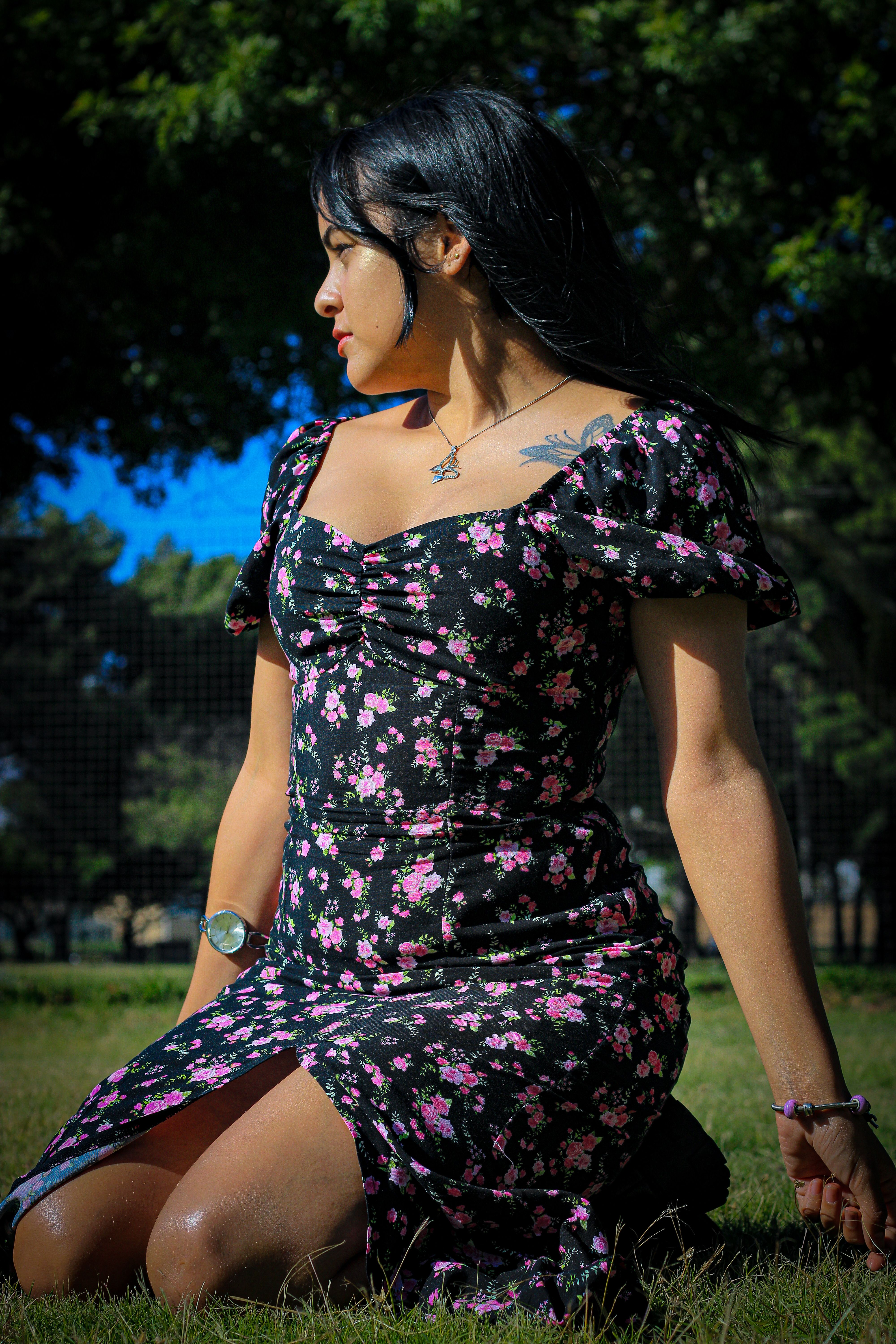 Brunette Woman in Sundress Kneeling on Grass in Park · Free Stock Photo
