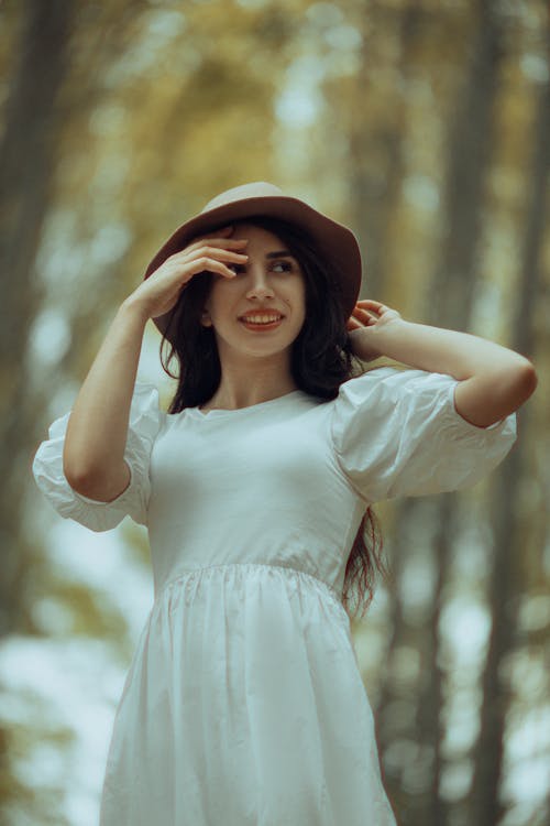 Smiling Woman in Hat and White Dress
