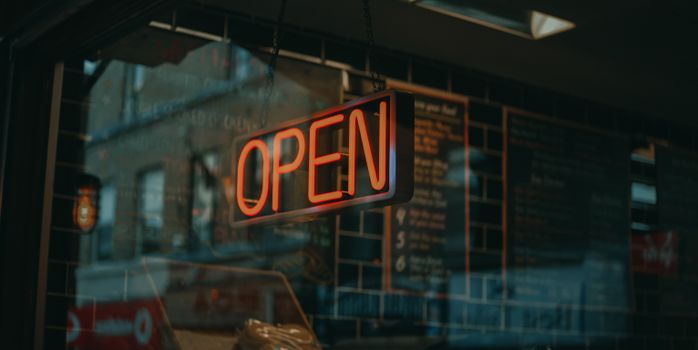 Illuminated neon open sign in a café window, Altrincham, England at night.