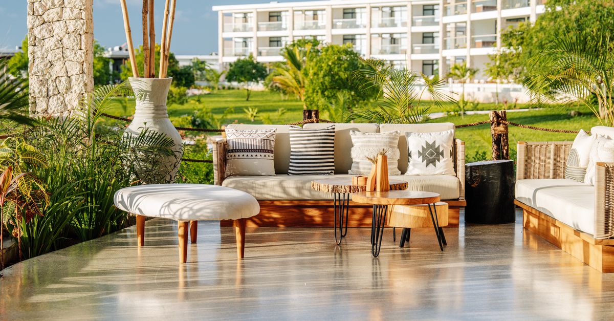 Elegant outdoor terrace at a luxury resort in Zanzibar, showcasing stylish furniture and tropical greenery.