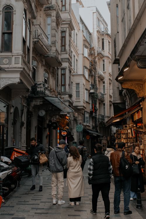 Free Narrow street in a historic old town bustling with pedestrians and vintage architecture. Stock Photo