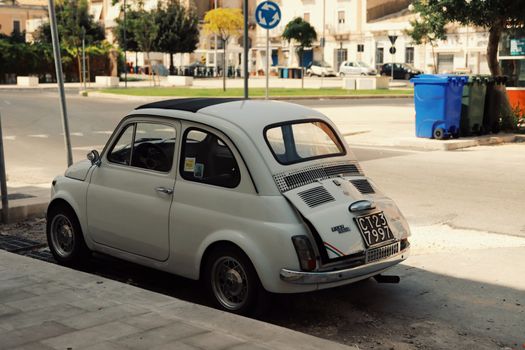 Classic Fiat 500 resting on a street in sunny Syracuse, Sicily, showcasing Italian charm.