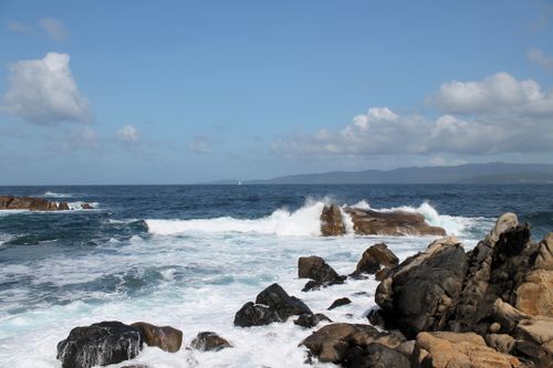 Free Capture of powerful waves crashing on coastal rocks under a bright sky. Stock Photo