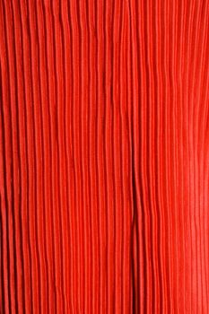 Detailed view of a pleated red fabric with textured pattern, ideal for design projects.