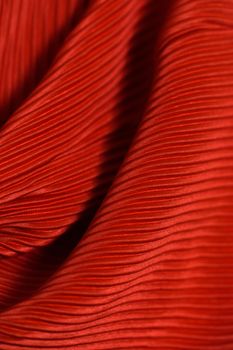 Detailed image of red pleated fabric with a soft and smooth texture.