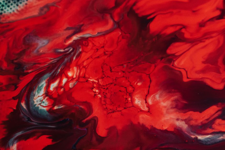 Dynamic abstract art featuring swirling red and white paint with fluid textures.