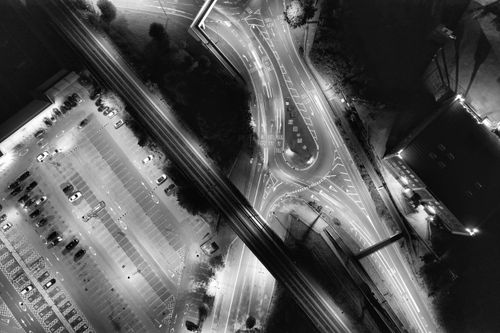 Free Black and white aerial view of an illuminated road network and parking lot in Luton, England at night. Stock Photo