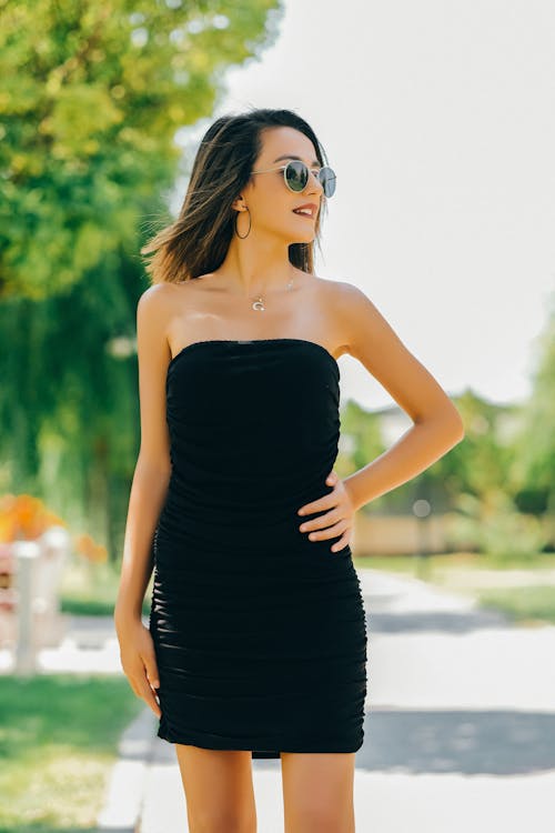 Woman Standing in Sunglasses and Black Sequin Dress