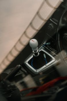 High-angle view of a sports car interior featuring a gear lever and sleek design.
