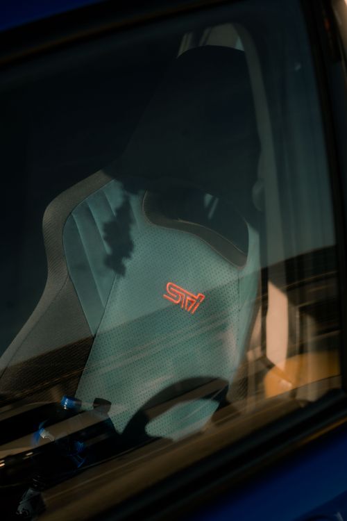 Free Close-up of a sunlit Subaru sports car seat featuring logo detail. Stock Photo