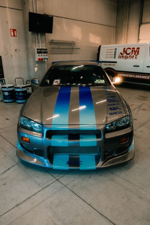 Free A sleek, customized Nissan Skyline sports car with stripes in a garage setting in Cremona, Italy. Stock Photo