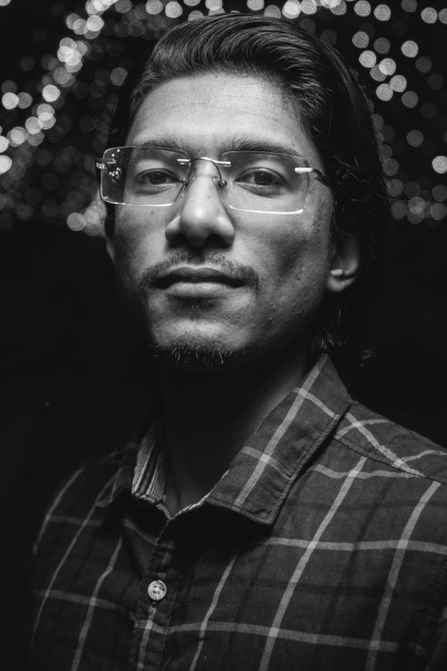 Free Intriguing black and white portrait of a man wearing eyeglasses and a checkered shirt. Stock Photo