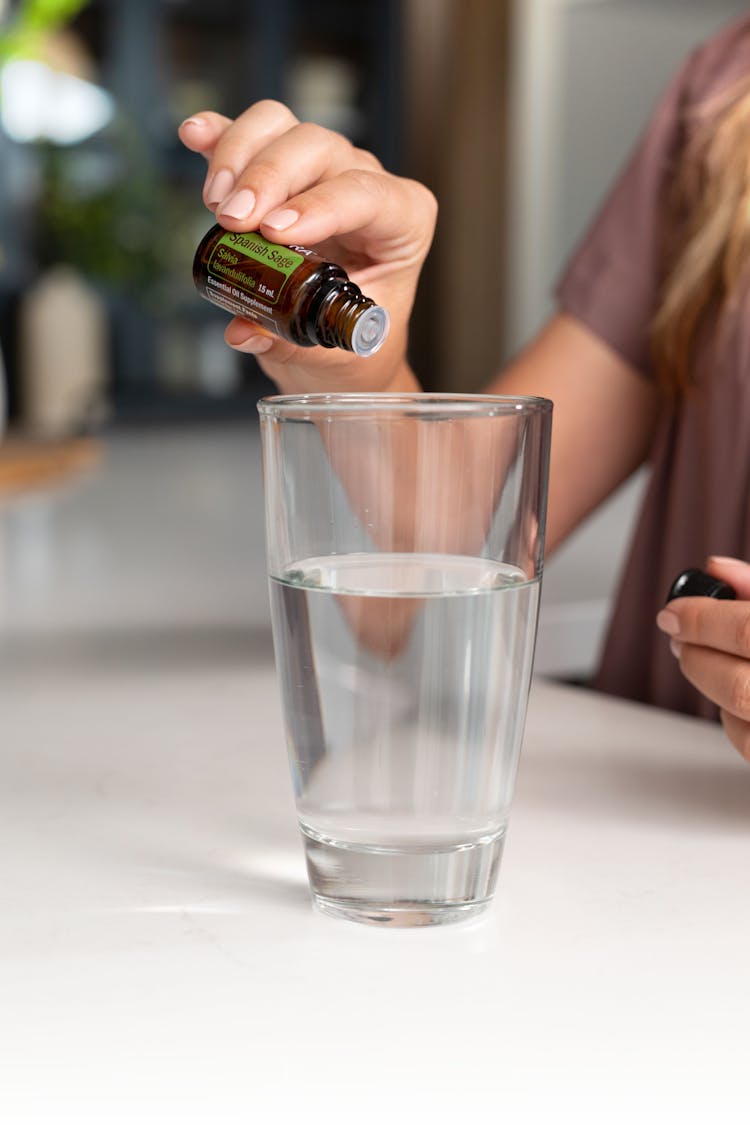 Hand Holding Bottle And Glass Of Water