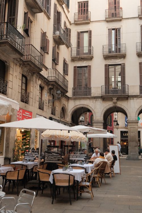 Free Elegant outdoor dining scene in Barcelona's historic Gothic Quarter with classic architecture and warm ambiance. Stock Photo