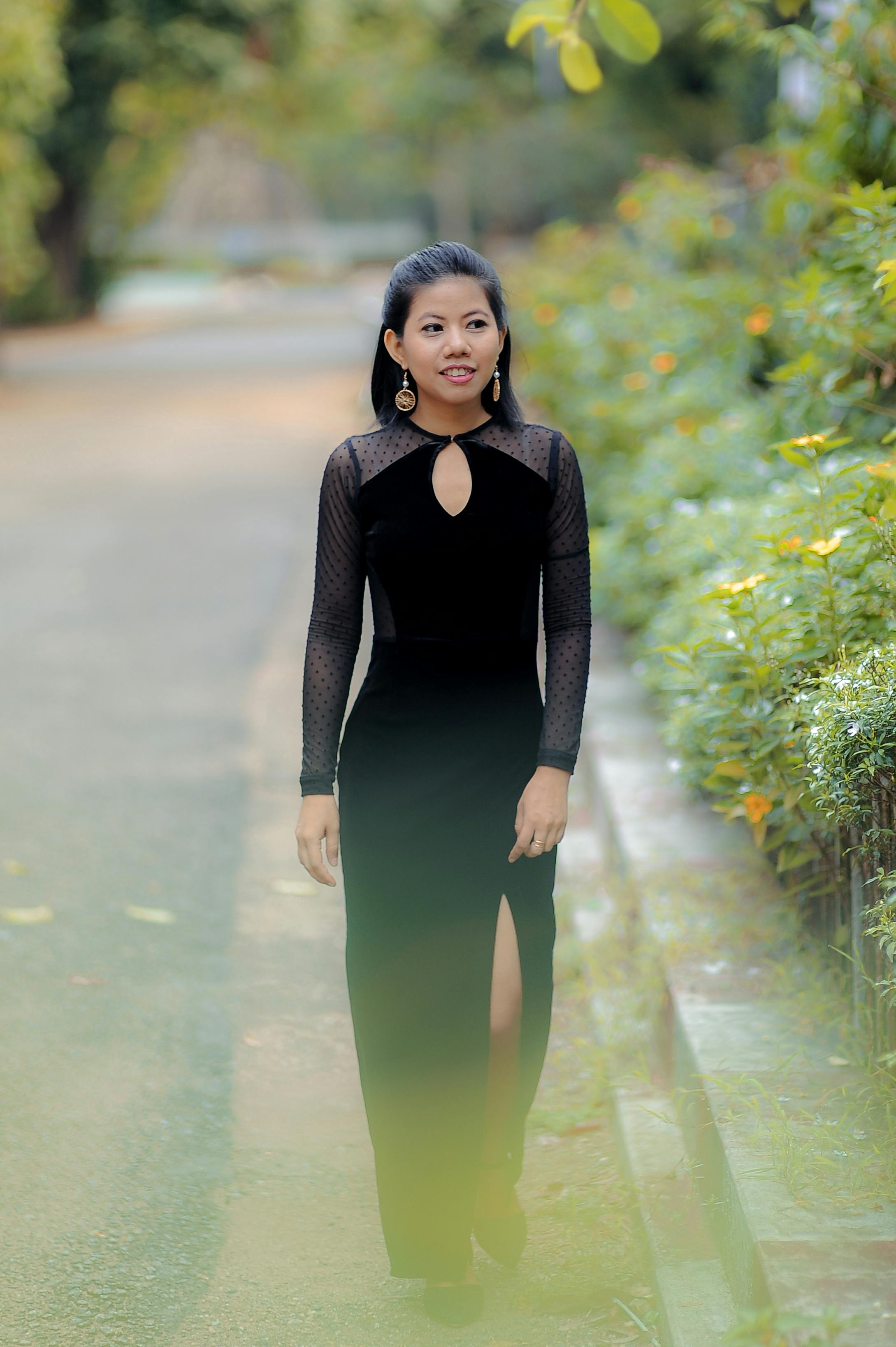 Elegant Woman in a Black Dress Walking in a Park · Free Stock Photo