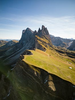 A stunning aerial view of a sharp rocky mountain range under a clear blue sky.