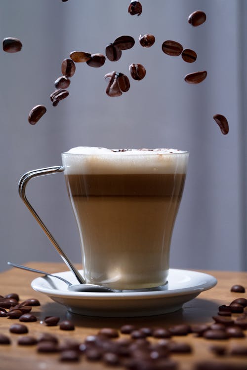 Coffee Beans Falling on Coffee in Glass