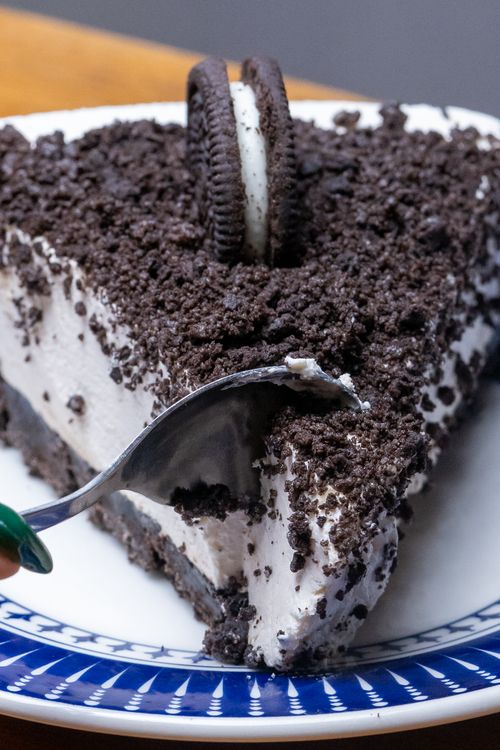 Free Close-up of a slice of Oreo crumble cake with a spoon, perfect for dessert lovers. Stock Photo