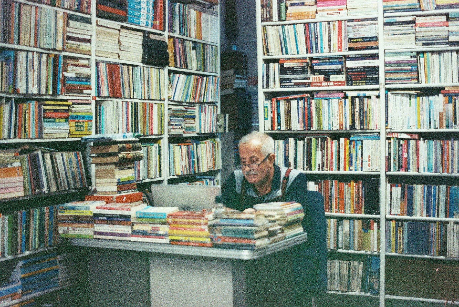 Clifford Geertz books beside handwritten field notes, Indonesian cultural maps, warm library lighting