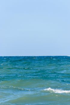 Peaceful ocean scene with gentle waves and clear blue sky, perfect for relaxation themes.