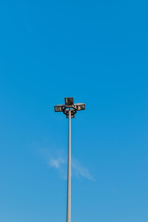 Free Vertical shot of a streetlight against a clear blue sky, capturing minimalistic urban scenery. Stock Photo