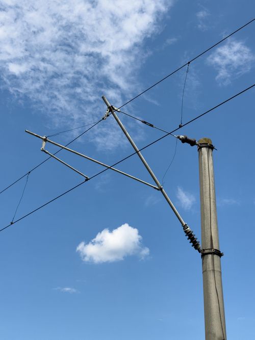 Free Aerial transmission wires and pole set against a bright blue sky in Comuna Țifești, Romania. Stock Photo
