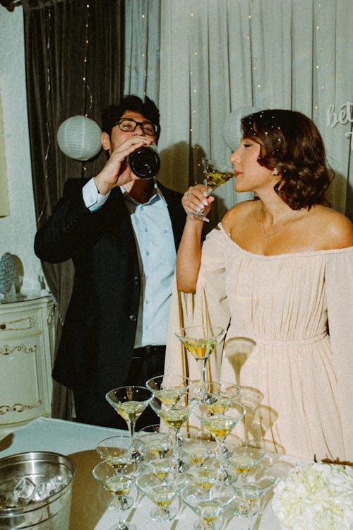 Woman in Dress and Man in Suit Drinking on Party