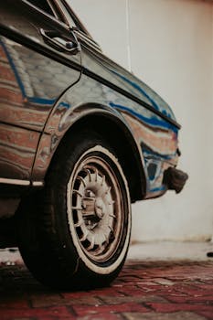 Retro Mercedes-Benz showcasing detailed wheel and mirrored surface.