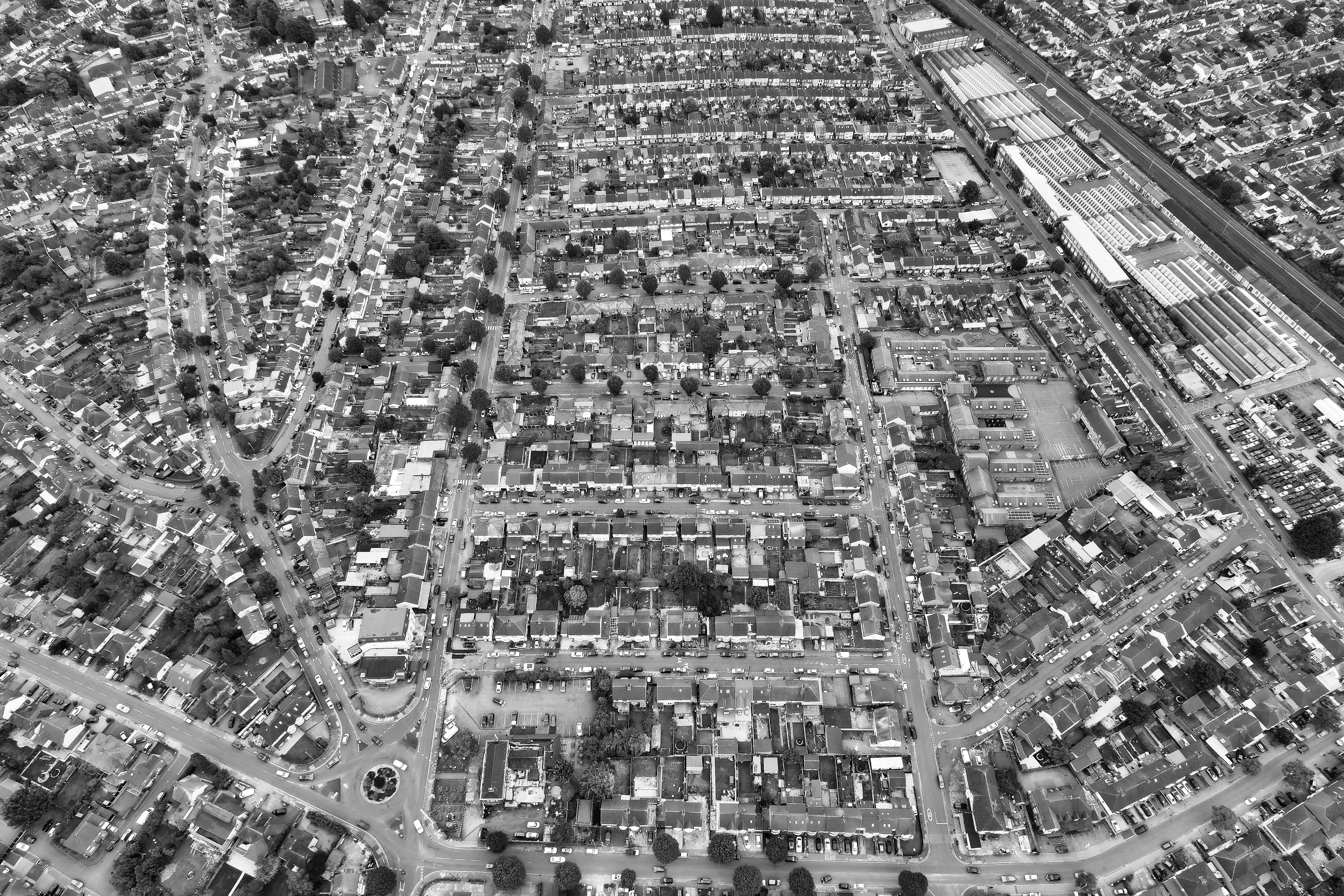 A high-angle aerial view of Luton's residential neighborhood in grayscale, showcasing urban architecture.